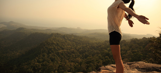 young freedom woman enjoy the view at mountain peak cliff