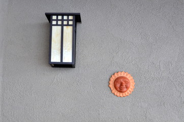 Terracotta sun face with wall light