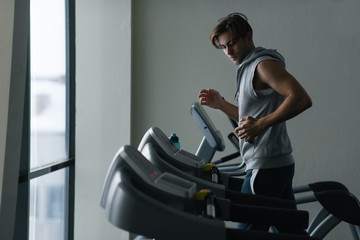 Young man running on  treadmills in the gym