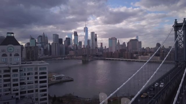 cloudy flying right shot of Manhattan Bridge with NYC in BG