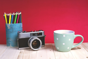 A cup coffee with old camera on red wallpaper background