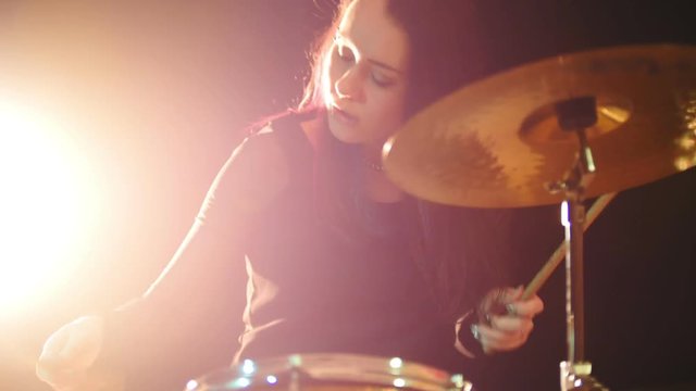 Young woman percussion drummer performing with drums