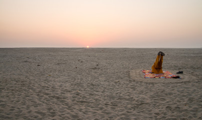 Man practising yoga on riverbank of Ganges