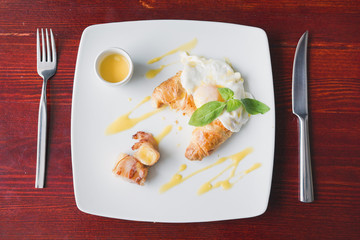 Fried eggs with bacon on white plate - breakfast in restaurant
