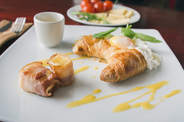 Fried eggs with bacon on white plate - breakfast in restaurant, selective focus