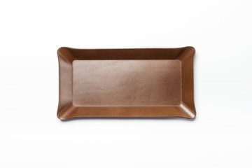 A brown leather pencil tray isolated white.
