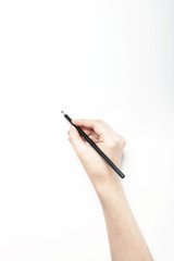 A woman hand hold a black pencils isolated white.