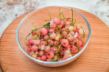 frozen white currants in a glass container on a wooden stand