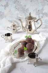 Dark chocolate truffles sprinkled with cocoa . Sweet candy and white background. Aristocratic breakfast with sweets and coffee