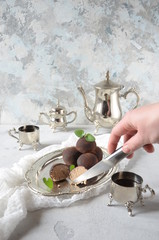 Dark chocolate truffles sprinkled with cocoa . Sweet candy and white background. Aristocratic breakfast with sweets and coffee