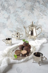 Dark chocolate truffles sprinkled with cocoa . Sweet candy and white background. Aristocratic breakfast with sweets and coffee