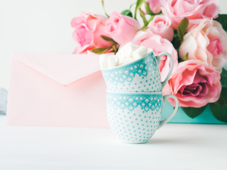 Two coffee cups with marshmallow card for Valentine's or mother woman day. Wedding baby birthday romantic date invitation. Background with roses tray romantic textile