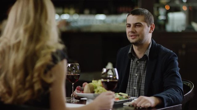 back view of a blondie talking to boyfriend in restaurant