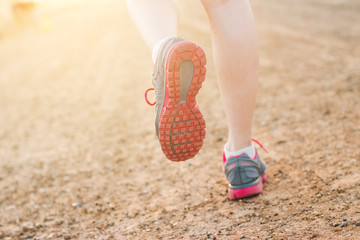 Closeup on shoes young lady running on the way ., at time sunset.