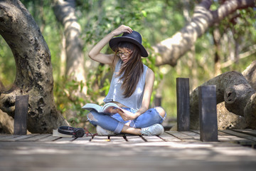Obraz premium woman enjoy reading a book under the tree in park