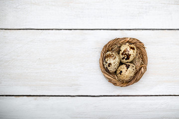 Easter eggs in a nest on a white wooden background. view from abov