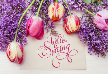 frame from tulips and lilac and place for text greeting card and text Hello Spring. Calligraphy lettering