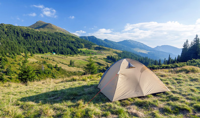 Tourist tent in mountains on a summer sunny day