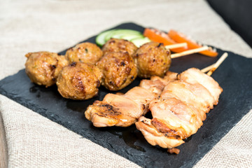 tasty grilled meat and vegetables skewers on a slate plate