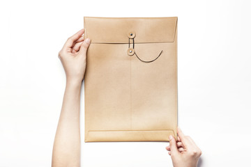 Woman hand hold a letter with leather envelope isolated white