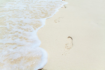 Footprints on white sandy beach