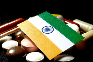Indian flag with lot of medical pills isolated on black background