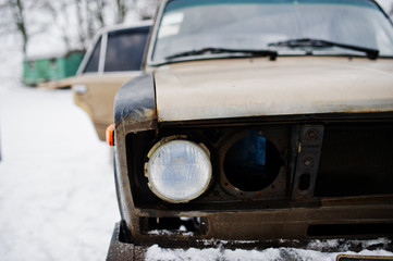 Headlights of old soviet car on snowy weather.