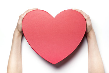 Woman hand hold a red heart gift box isolated white.