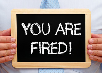 You are fired - Businessman holding chalkboard with text