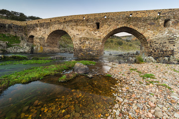 Ancient Roman bridge over the Salor river, located near Aliseda. Extremadura. Spain.