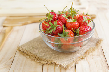 Close up shot of nature fresh strawberry in glass bowl on wooden table