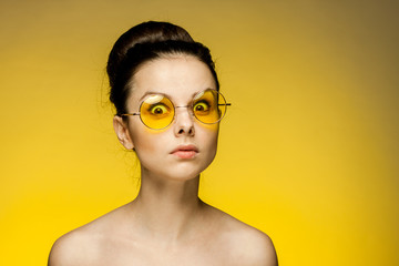 shocked woman with bulging eyes against a yellow background