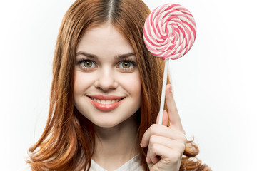 happy woman with round lollipops on a stick, light background