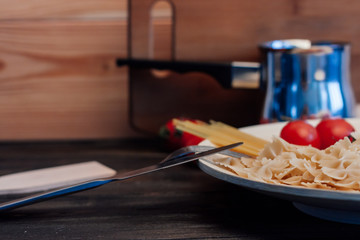 bucket in the background and vermicelli with spaghetti, tomatoes on a plate
