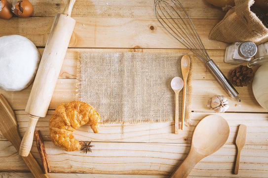 Blank hemp sackcloth and bakery ingredients on wooden table background with copy space