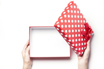 woman hand hold a empty red dot gift box with ribbon isolated white.
