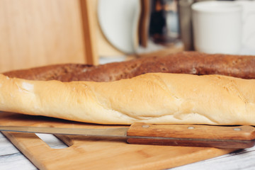 baguettes on the table and sharp knife on the board