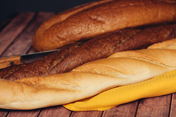yellow napkin, knife and baguettes with a loaf