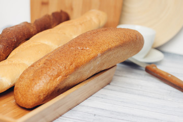 baguettes on a wooden board and a sharp knife on the table