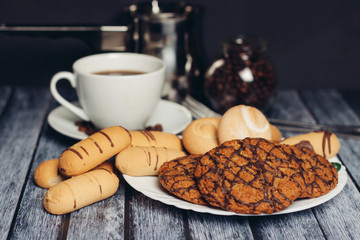 cookies of different kinds on a saucer a cup of coffee with coffee beans