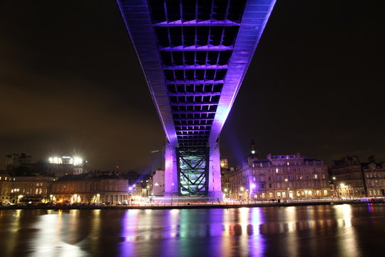 Striking view of the underside of the Tyne bridge in Newcastle-Upon-Tyne and the Quayside, both brightly lit