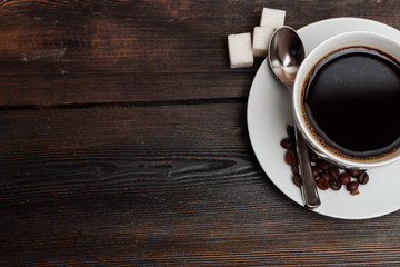 drink in a glass stands on a saucer and sugar cubes on a table