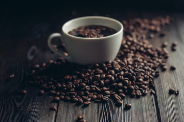 cup with a drink and coffee beans around