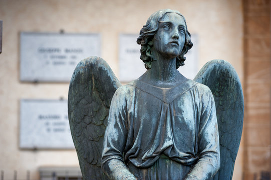 The afflicted angel kneeling on the tomb turns his gaze to the sky