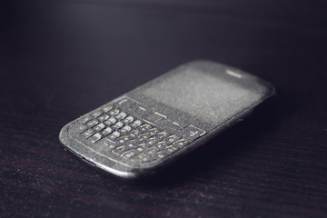 Old smartphone with dust on black shelf © macondos