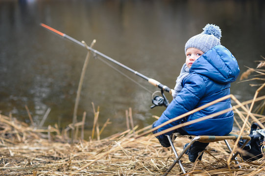 Little boy fishing on the river bank