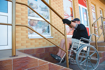 A disabled man on Wheelchair trying to climb ramp entrance. Handicapped male make their way into the market.