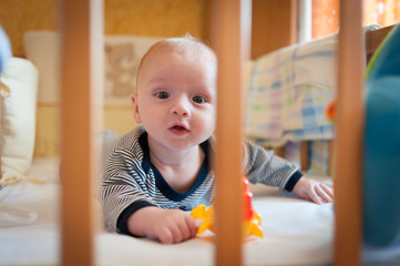 little baby boy lying in a crib