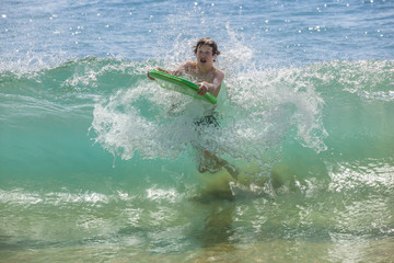 boy has fun surfing in the waves