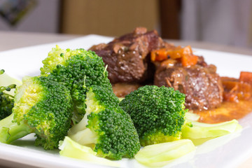 Stew with vegetables meat with broccoli is on the plate.